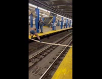 Guy walks across wood planks over tracks 