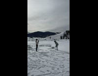 Man in a white jacket throws snow in the air 