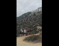 Red body paint girl poses hollywood sign 