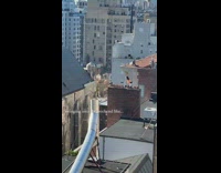 Guy sits on swing attached to rooftop 