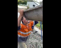 Guy drinks beer from cement dispenser 