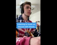 Guy with headphones on on computer friend singing