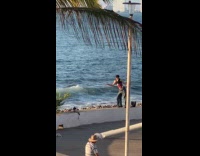 Man crop top poses by the beach