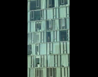 Woman stands in front of a window in her apartment wearing a swimsuit