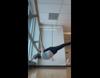 Lady Stretches Arms and Legs on Studio Handrail