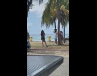 Man white top bag lean palm tree