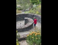 Man in red shirt lifts foot and steps on the rocks