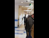 man black wet suit runs with surf board in hallway