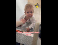 Mom holds little boy climbed up ladder