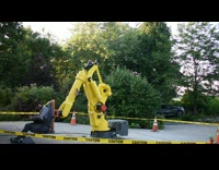 Yellow robot arm spins guy around caution
