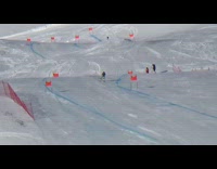 Skier skis down mountain track fast, jumps over hump and fails