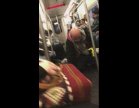 Crazy man on subway train kneels down on the ground and shouts, has a crossbow