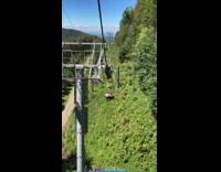 Blue gondola lift through green grass mountain 