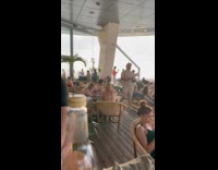 Woman bikini poses on rooftop pool rails