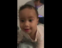 Baby laying down on bed gets up when he hears the coco melon song