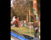 Three men in costume dances at school yard