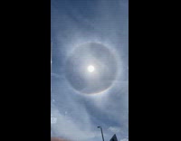 Sun in the sky with a rainbow halo around it