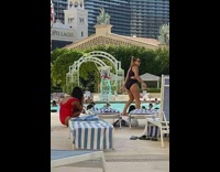 Black bathing suit girl poses pool hotel 