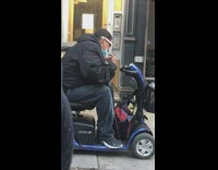 Guy on blue mobility scooter dances sidewalk 