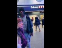 Man wearing redhawks costume at subway station