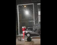 Man on a bull statue shouts while a woman claps