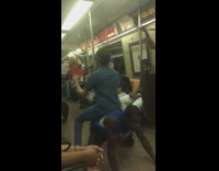 man in blue cut off shirt dances under legs of another man 