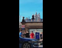 Two men dance on top of the train station