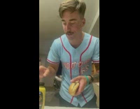 Guy films himself eating spicy brown mustard inside hot dog bun 
