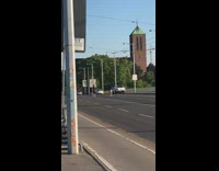 Man and woman dance middle of the road cars pass by 