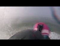 Red blue jet ski jumps off wave and does a flip in the air, helmet camera