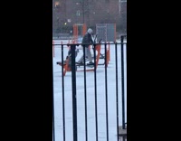 Man uses exercise equipment in park while it snows