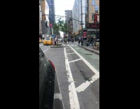 Guy rides a bike with huge color stack of cargo inside wagon