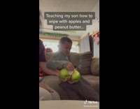 Little boy wipes peanut butter off apples