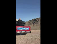 Traveling piano and dog man playing on top of red truck 