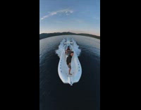 Guy shows wide angle view of end of white boat in lake 