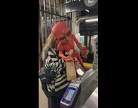 Girl at subway station holds red alien 