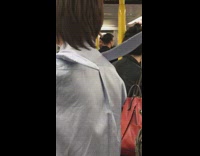 Guy wears a blue striped button down shirt with bunny ears on shoulders on subway
