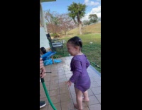 Kid playing drinks water from the hose