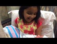 Excited girl holds newborn baby in arms