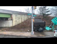 A truck that ran over a street sign is up a hill