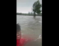 Man red hoodie swim in flooded soccer field