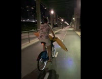 Guy bikes with hot dog floatie 