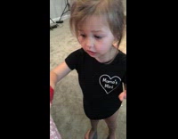 Little girl colors hand red super hero hand