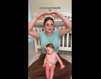 Woman and baby compares their arm length