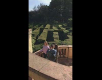 Girl takes picture in front of hedge maze