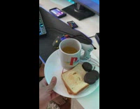 Guy brings kid sandwich sits down at computer