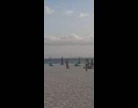 Woman in beach gown films selfie video while dancing to Reggaeton