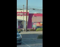 Woman brown hoodie dance behind car Pinkbox Doughnuts