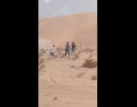 Couple roll arm dance on sand dunes