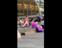 Woman yoga video shoot with people around